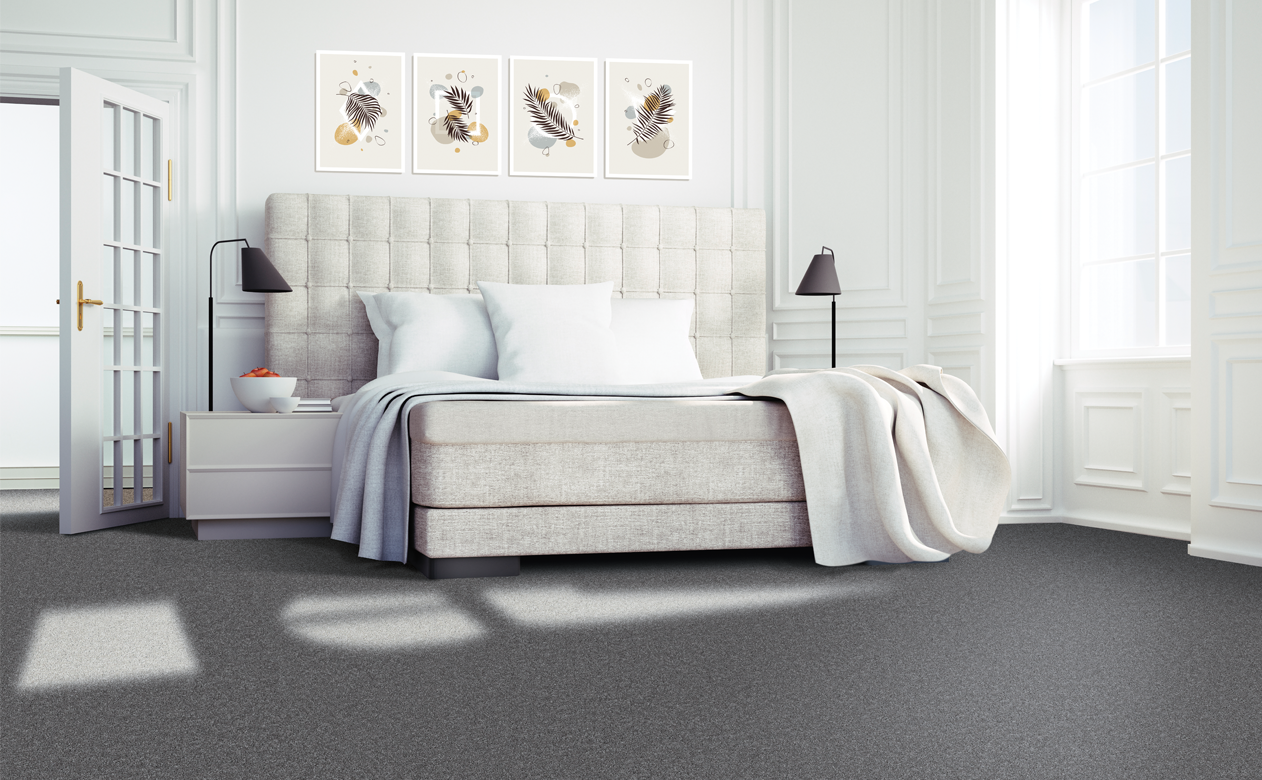Dark grey carpet in master bedroom with upholstered cream headboard 